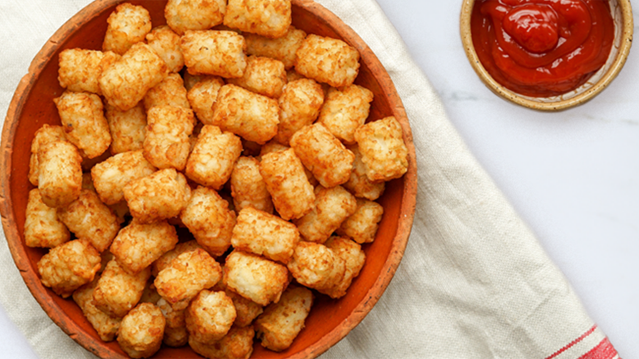 Plate of sweet potato tots and ketchup on the side