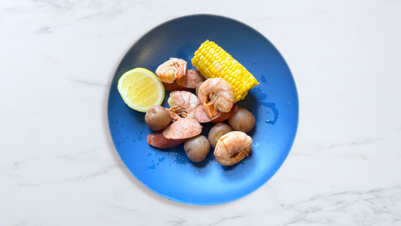 Plate of boiled corn, shrimp, and potatoes