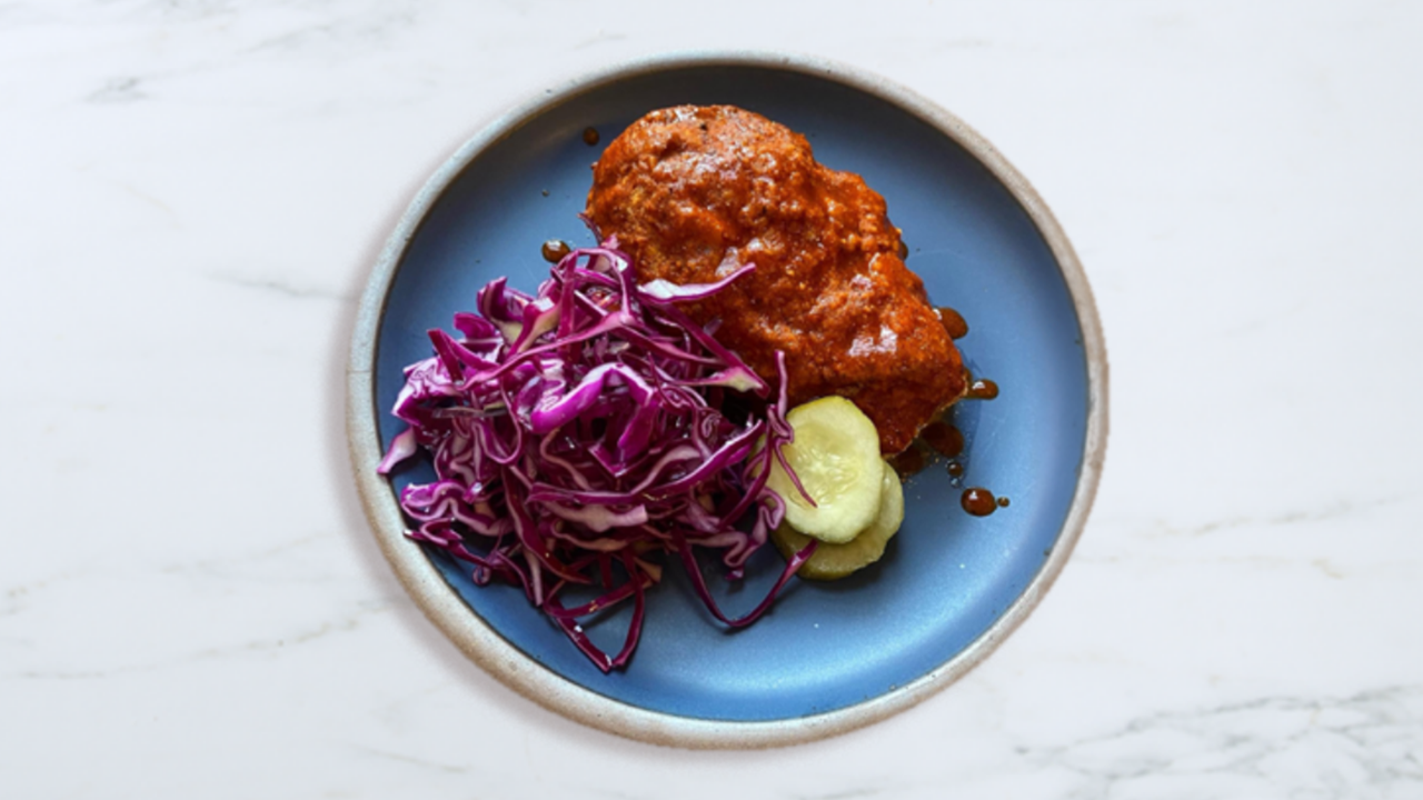 Nashville hot chicken with a side of slaw and pickles
