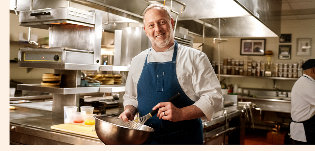 Franklin Becker holding a bowl and whisk