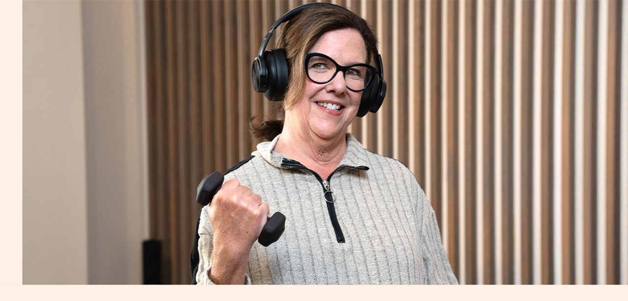 Jane wearing headphones lifting dumbbell